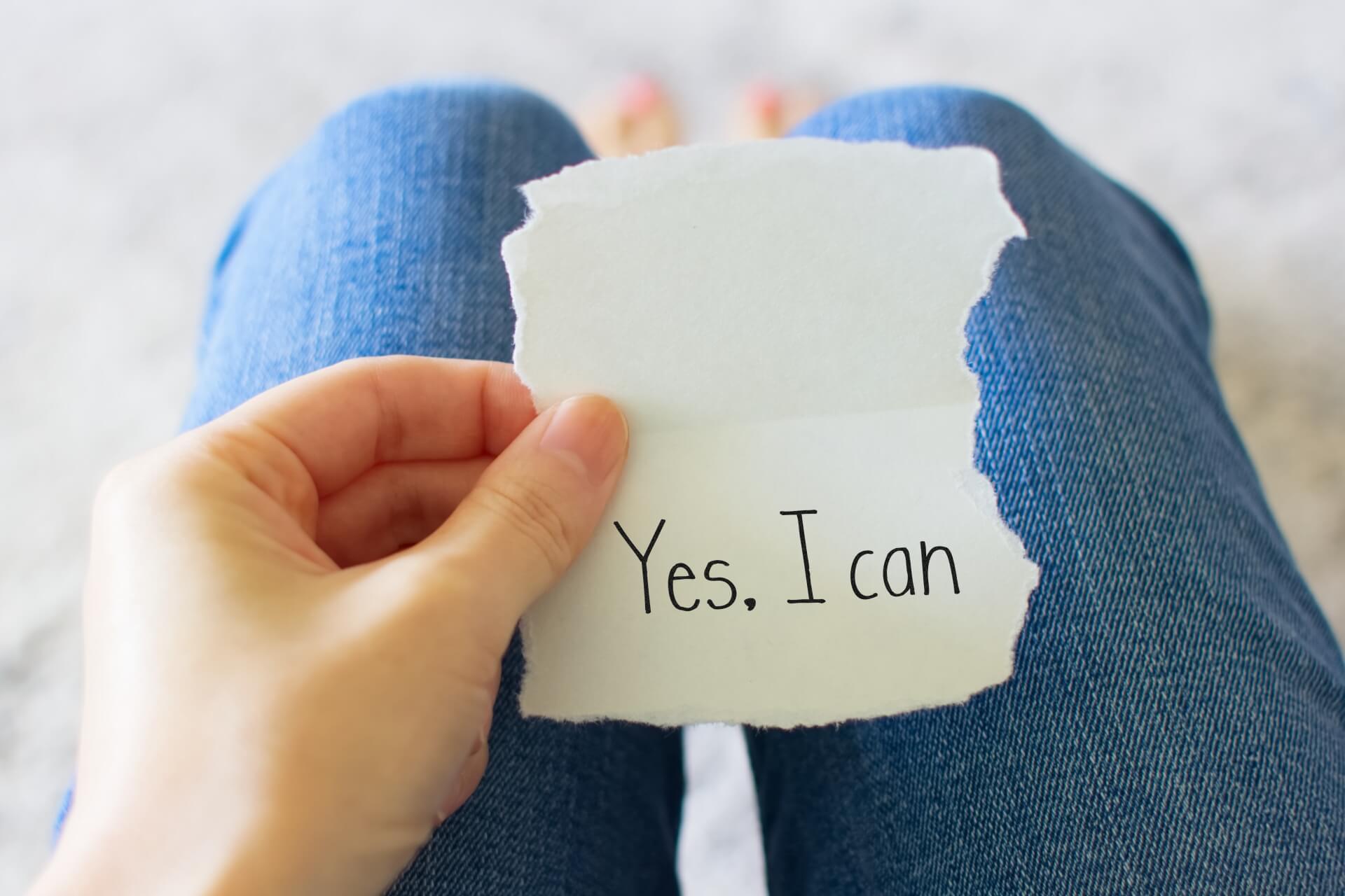 「Yes,I can」と書かれた紙を眺める人