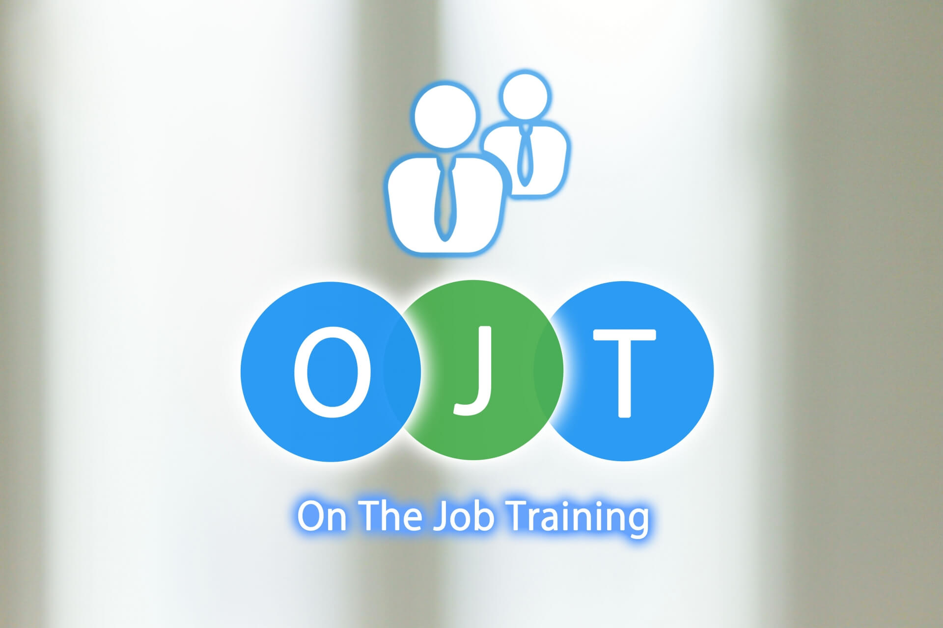 OJT(職場内訓練)の文字と、背後にビジネスパーソンのアイコンが描かれた、人材育成手法を説明するための画像。