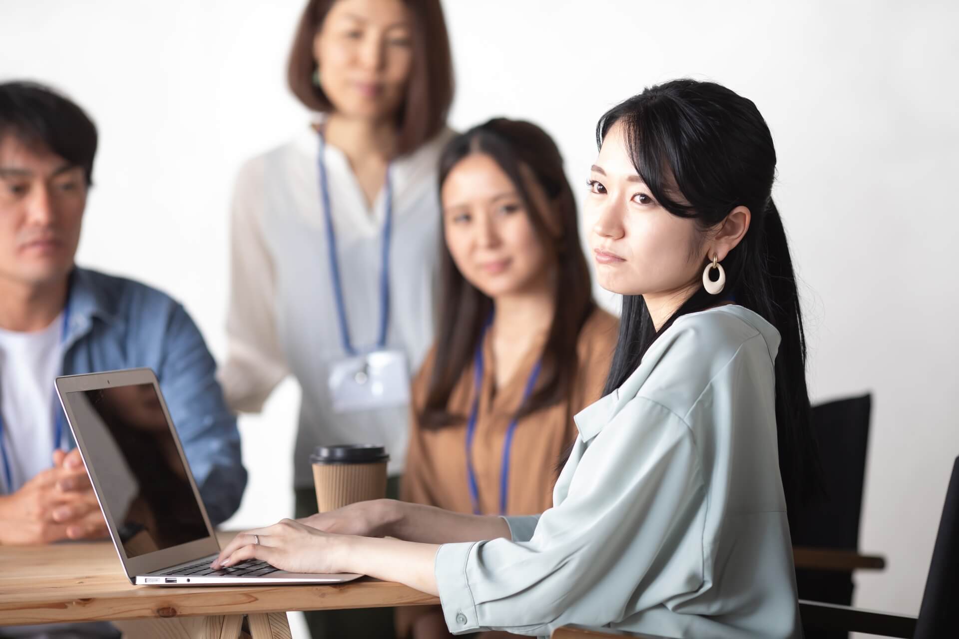 職場での人間関係や作業環境に悩み、不満げな表情でパソコンの前に座る女性従業員